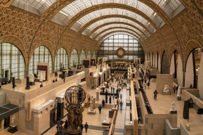 Grand interior of the Musée d'Orsay with visitors exploring the galleries