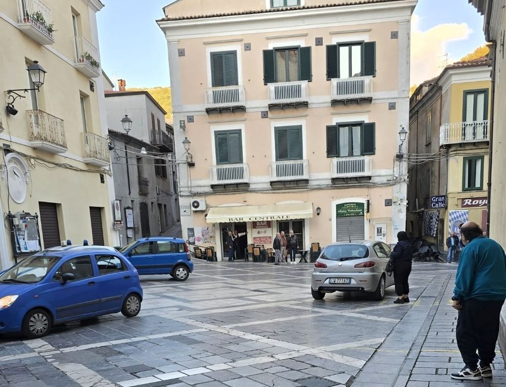 Street scene in central Mormanno, Calabria, with local buildings, cars and pedestrians